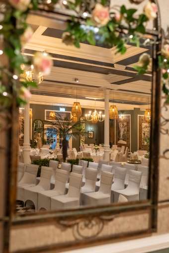 artistic shot taken in mirror of wedding ceremony in palm court