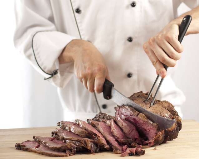 A chef carving a sirloin of beef for a Sunday roast