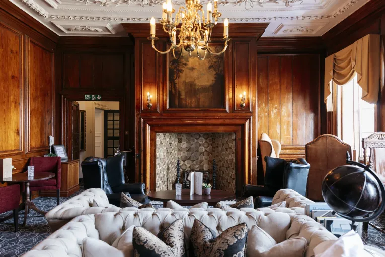 A view of the fireplace and seating in the wood-panelled Kingsley Lounge at The Royal Hotel Bideford