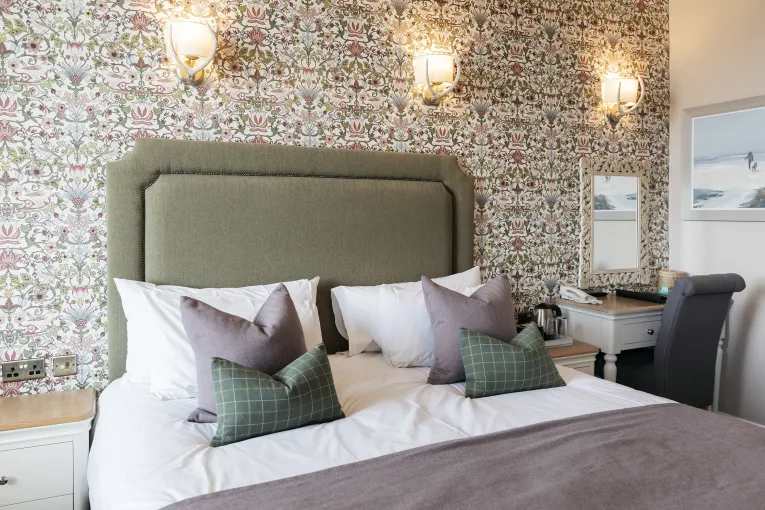 Pillows and a headboard of a double bed in one of the bedrooms in The Royal Hotel Bideford