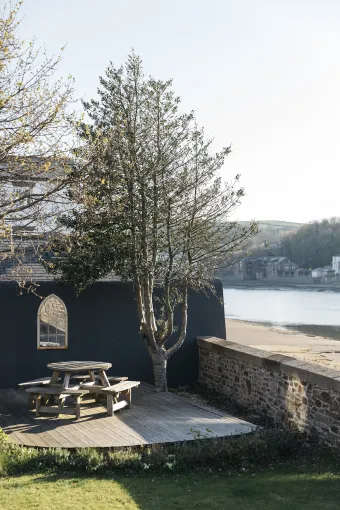 An outdoor walled garden space with a picnic table overlooking the River outside The Royal Hotel Bideford