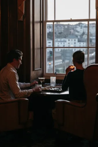 Guests enjoying the view from The Kingsley Lounge in The Royal Hotel Bideford with Cocktails and a game of Draughts