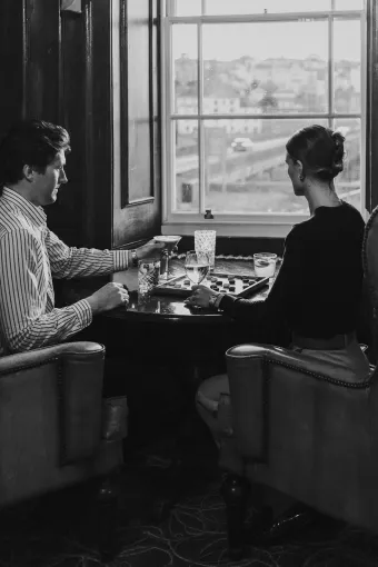 Two guests enjoying drinks and a game of Draughts inside the Kingsley Lounge at The Royal Hotel Bideford