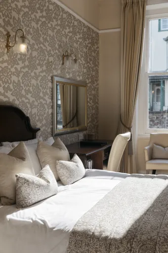 Sunlight from a window playing across a double bed in one of the bedrooms at The Royal Hotel Bideford