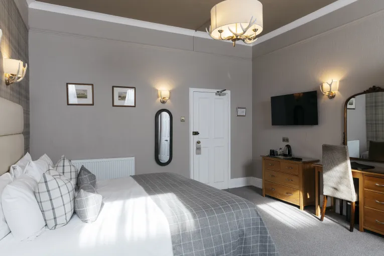 A bed, dresser and door inside one of the double bedrooms in The Royal Hotel Bideford