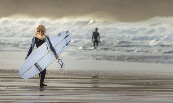 Woman with surfboard walking into sea