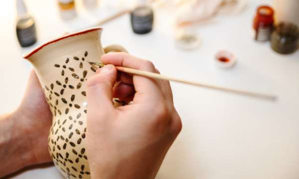 person painting pottery