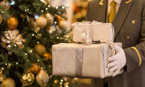 Man Holding Presents by tree 