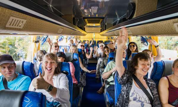 Group of happy travellers on a coach