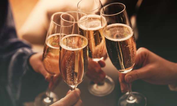 People clinking glasses with sparkling wine indoors at a function