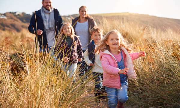 Family walking through and dunes in Autumn