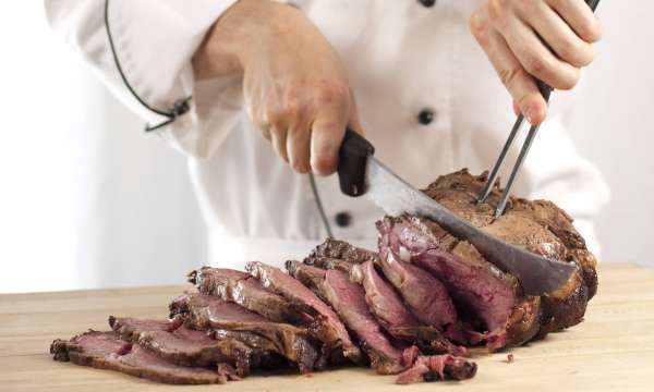 A chef carving a sirloin of beef for a Sunday roast
