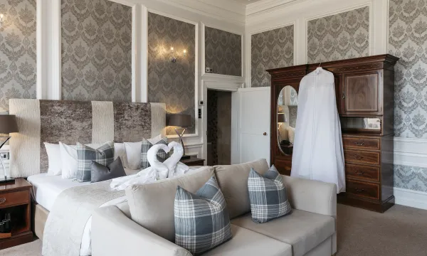 The Kingsley Suite at The Royal Hotel Bideford set out as a honeymoon suite with a wedding dress hanging on the wardrobe