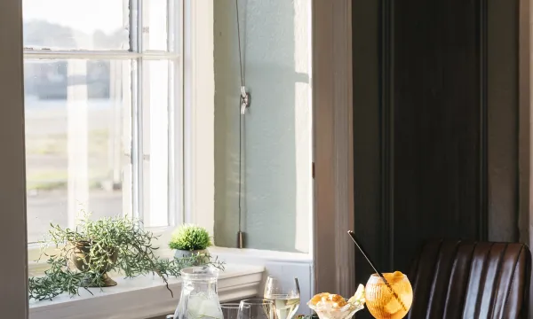 A selection of food and drinks on a table by a window inside The Royal Hotel Bideford