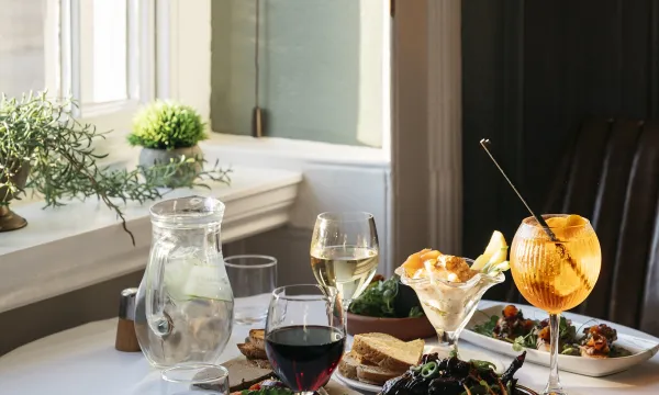 A selection of food and drinks laid out on a table by a window inside The Royal Hotel Bideford
