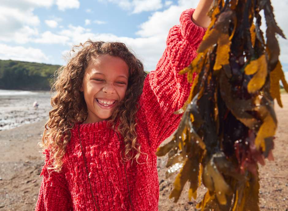 Girl holding seaweed wearing red jumper