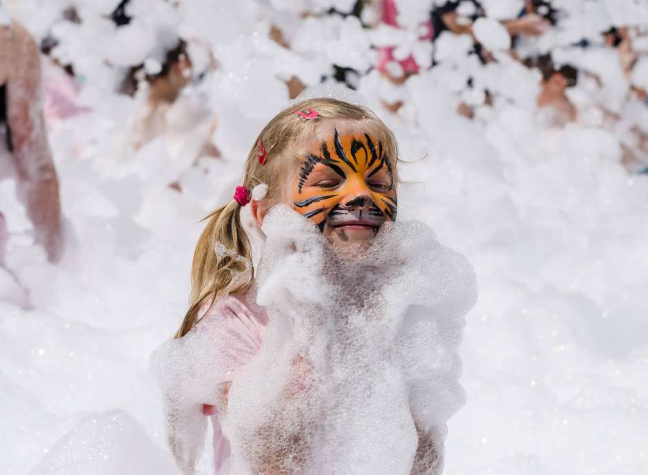 Girl with tiger face painting in foam party