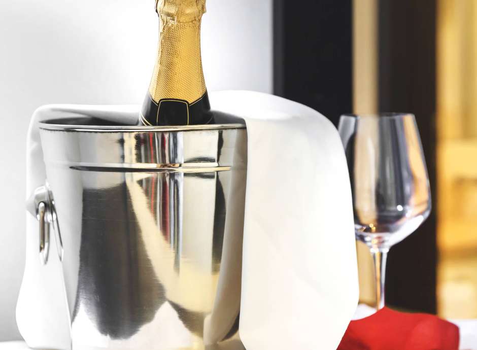 Bottle of cold wine or champagne in ice bucket