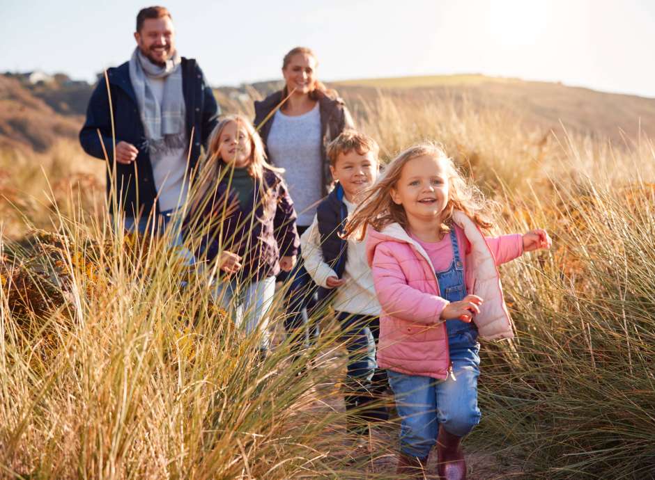 Family walking through and dunes in Autumn