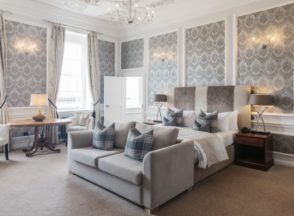 A large bedroom suite inside The Royal Hotel Bideford with a King-size bed, sofa and seating area