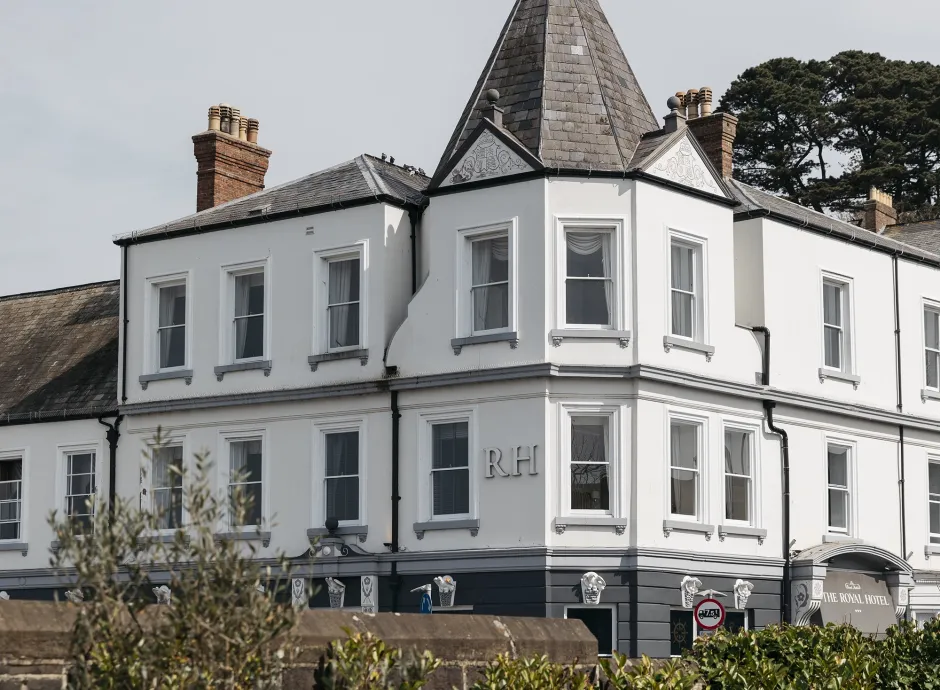 An exterior view of The Royal Hotel Bideford with bushes and a wall in the foreground