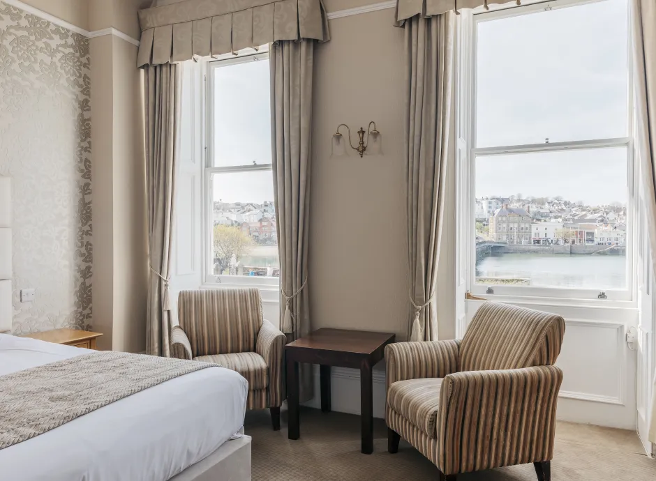 A seating area in a guest bedroom inside The Royal Hotel Bideford with views from the window over the river
