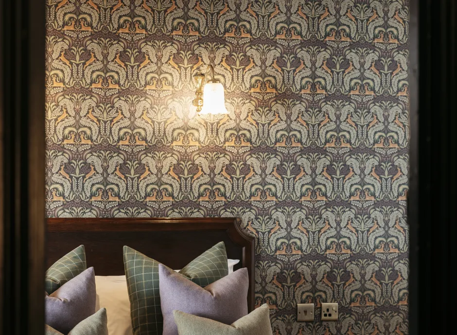 A view of pillows on a bed seen through a door frame inside The Royal Hotel Bideford