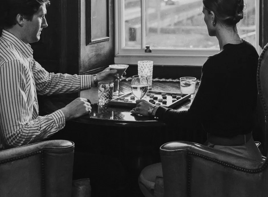 Two guests enjoying drinks and a game of Draughts inside the Kingsley Lounge at The Royal Hotel Bideford