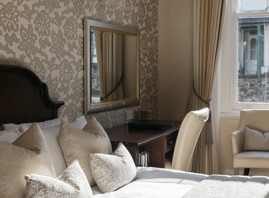 Sunlight from a window playing across a double bed in one of the bedrooms at The Royal Hotel Bideford