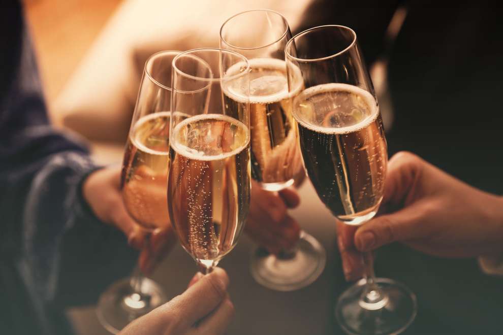 People clinking glasses with sparkling wine indoors at a function