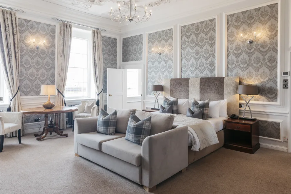 A large bedroom suite inside The Royal Hotel Bideford with a King-size bed, sofa and seating area
