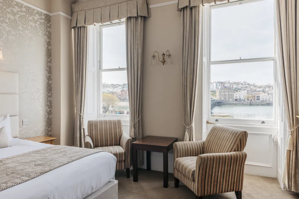 A seating area in a guest bedroom inside The Royal Hotel Bideford with views from the window over the river