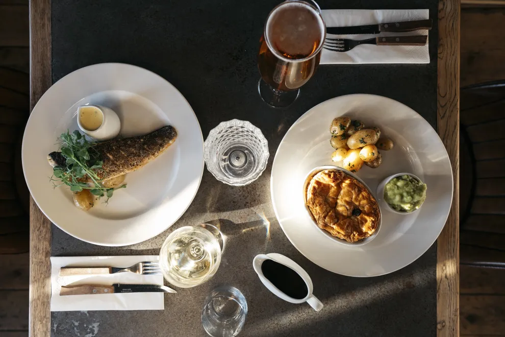A top down view of a fish dish and a pie dish on a table in The Royal Hotel Bideford